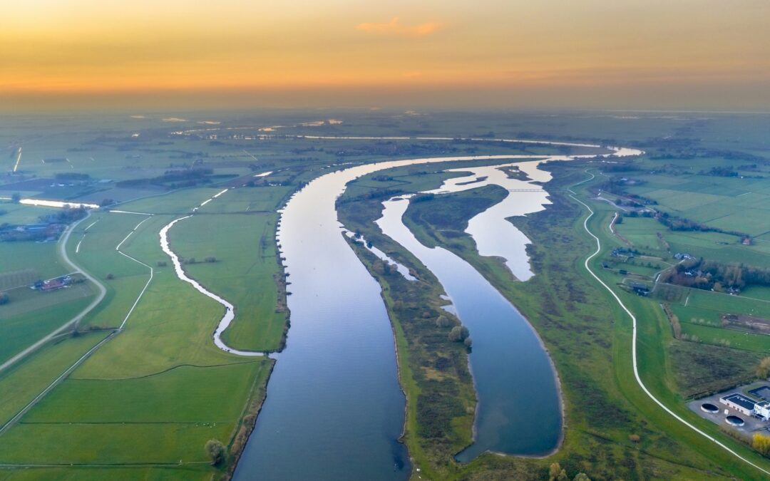 Lowland river IJssel through sunset landscape